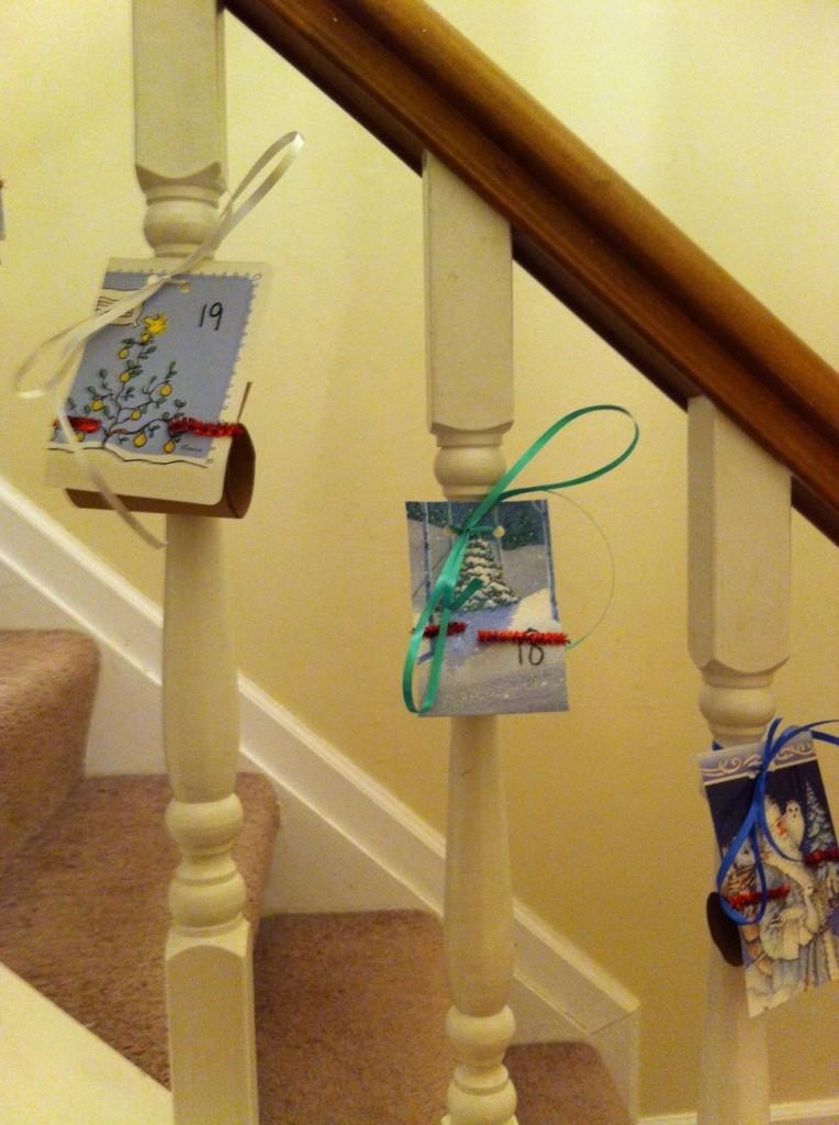Christmas cards cut out and tied to banister spindles for Advent